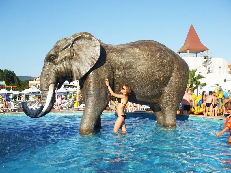 Woman at elephant statue in pool