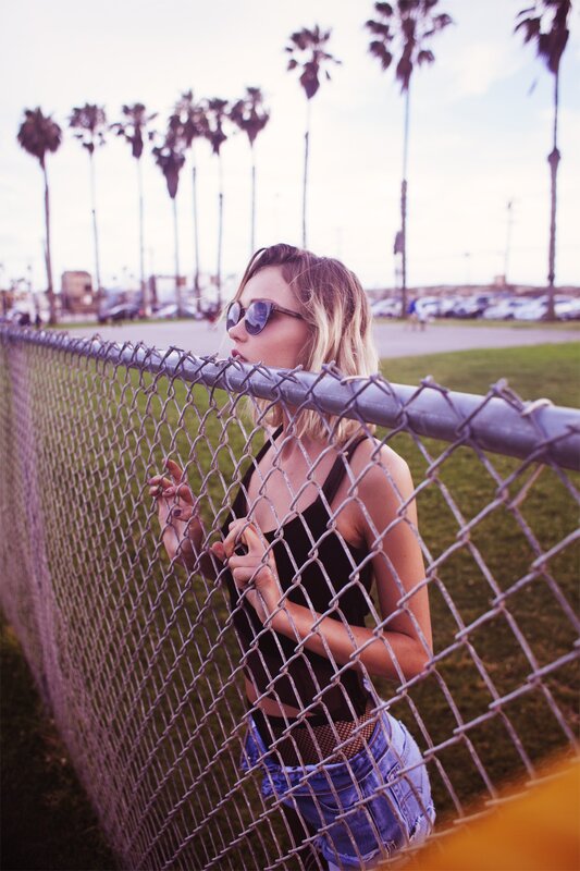 woman at fence with palm trees