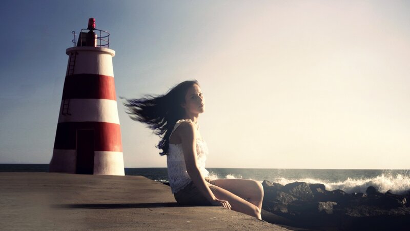 Woman at lighthouse by the sea