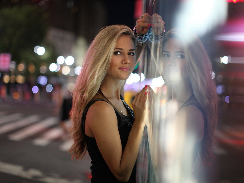 Woman at night by a pole