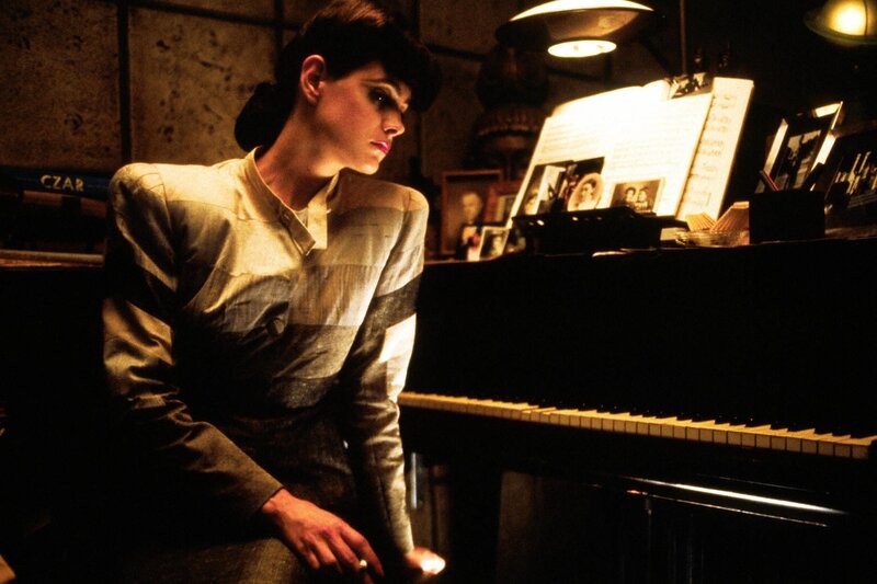woman at piano in dim light