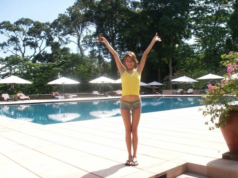 Woman at poolside with arms raised