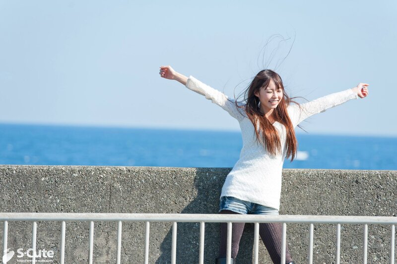 woman at seaside with arms outstretched