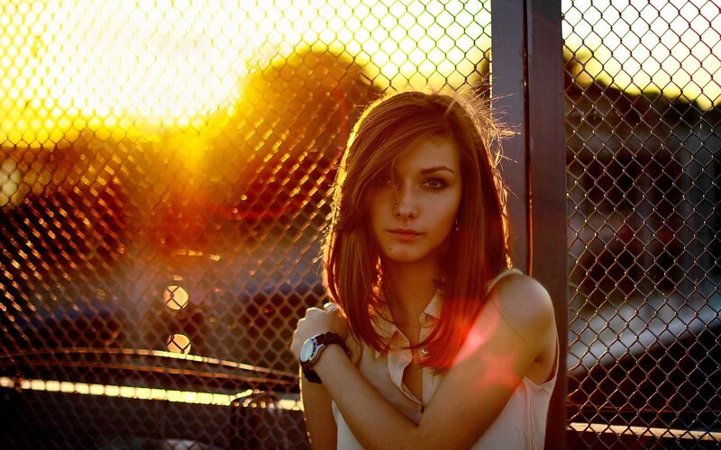 woman at sunset by fence