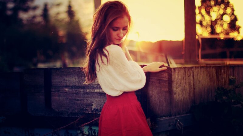 woman at sunset by fence