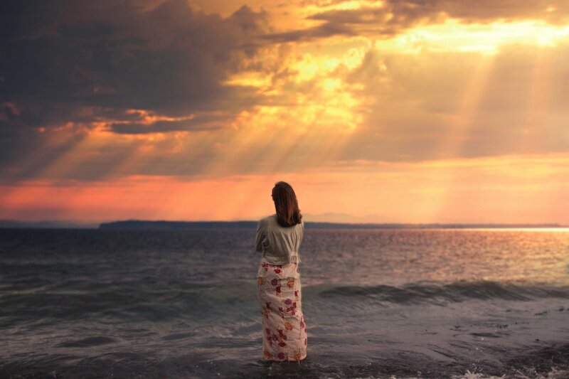 Woman at sunset by the sea