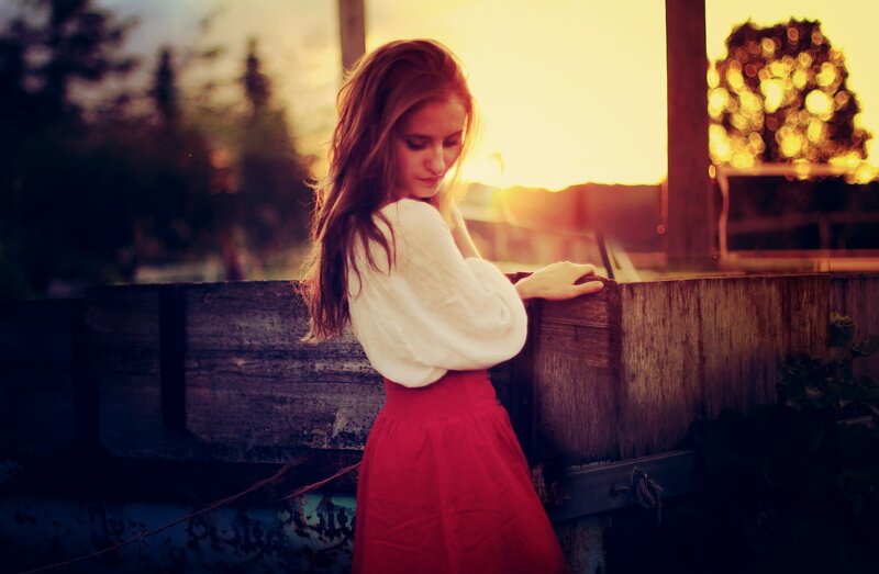 woman at sunset by wooden fence