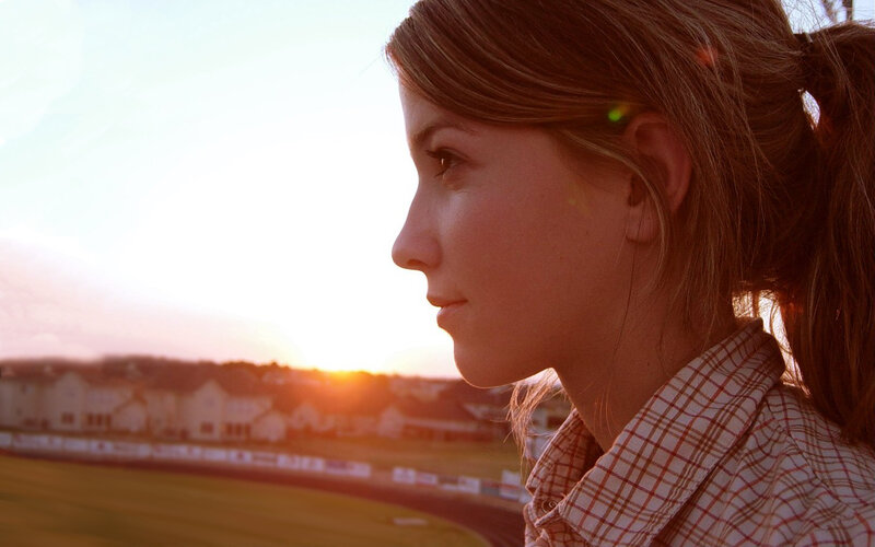 woman at sunset overlooking field