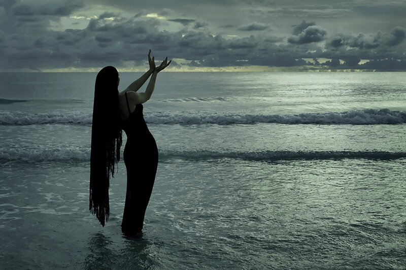 woman at the beach with arms raised