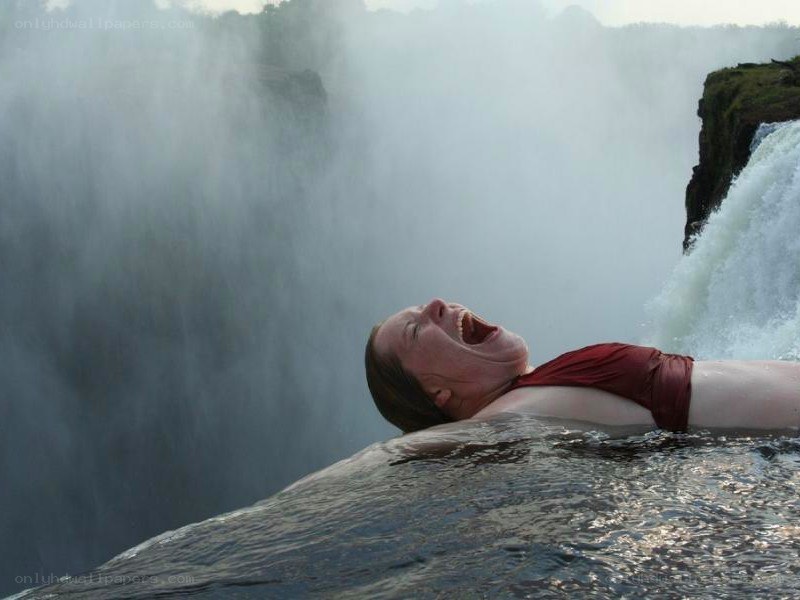 Woman at waterfall edge