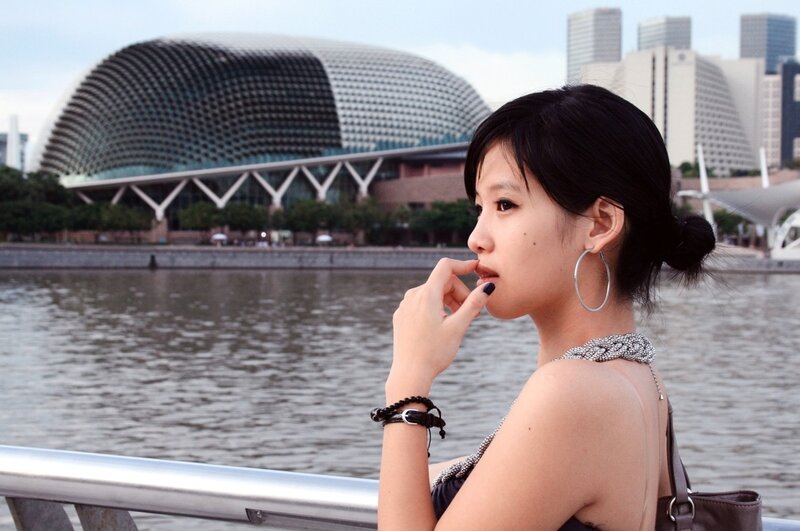 Woman at waterfront with modern architecture