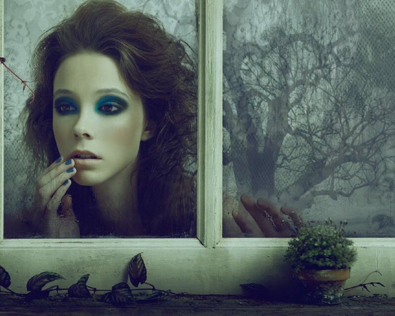 woman at window with green makeup