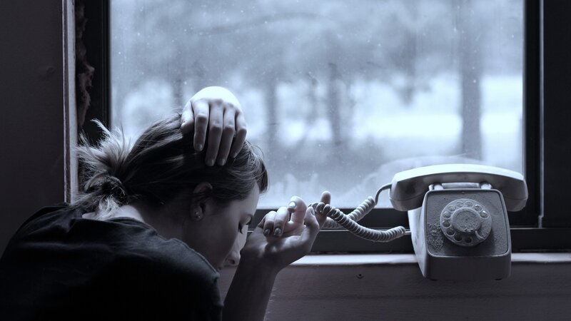 woman at window with rotary phone