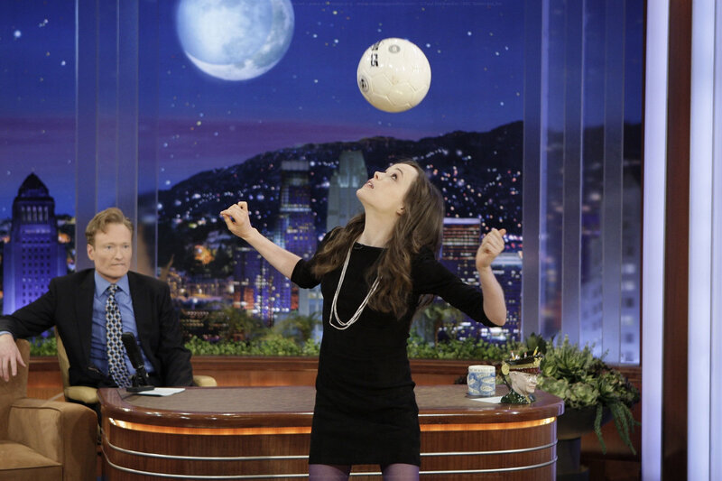 Woman balancing soccer ball on talk show