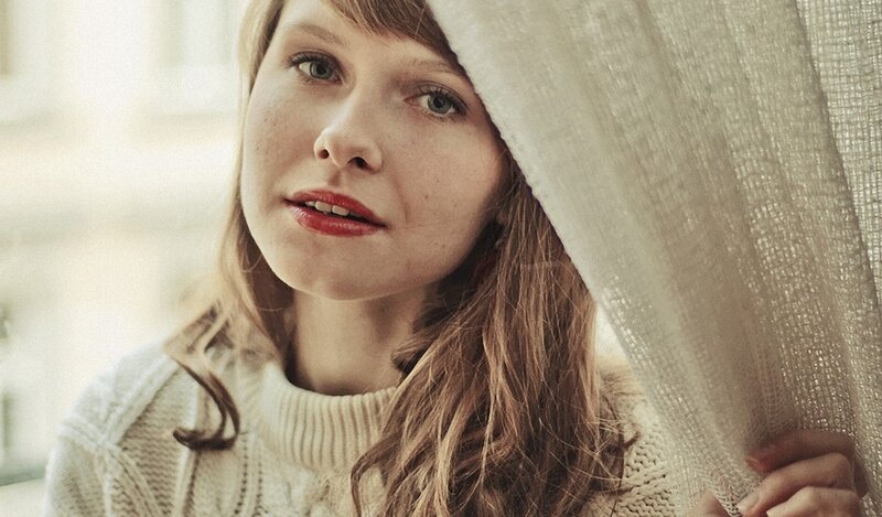woman behind a curtain