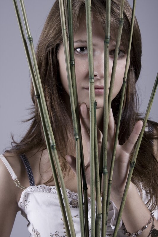 woman behind bamboo stalks