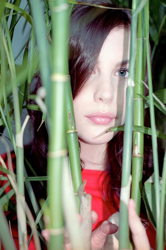 woman behind bamboo stalks