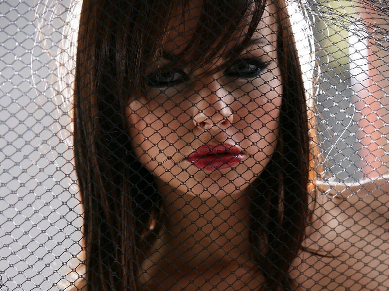 woman behind black mesh veil