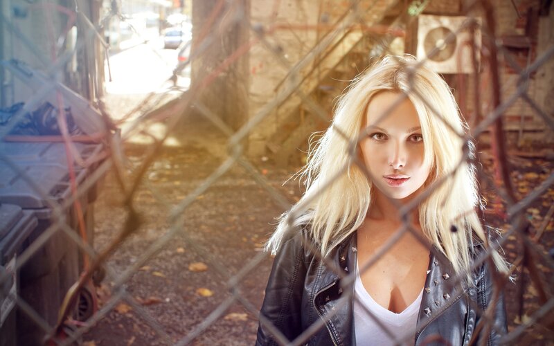 woman behind chain-link fence