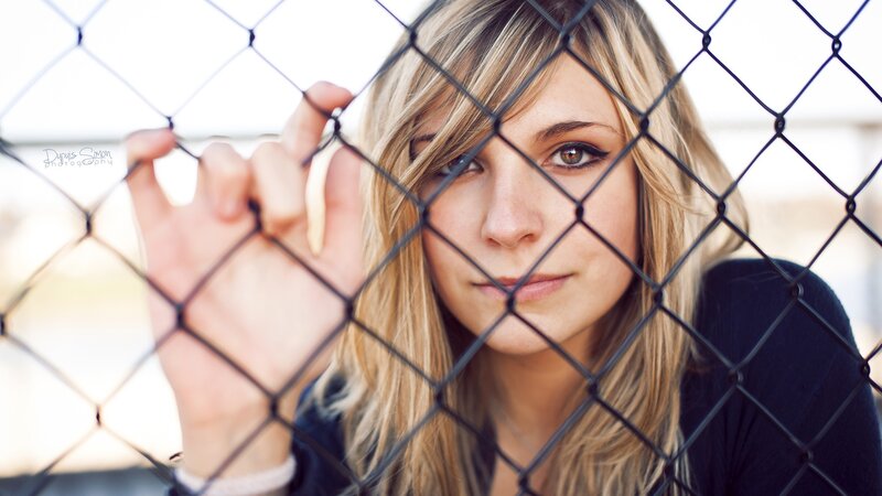 woman behind chain-link fence