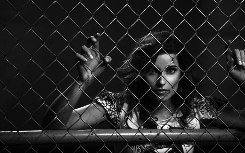woman behind chain-link fence