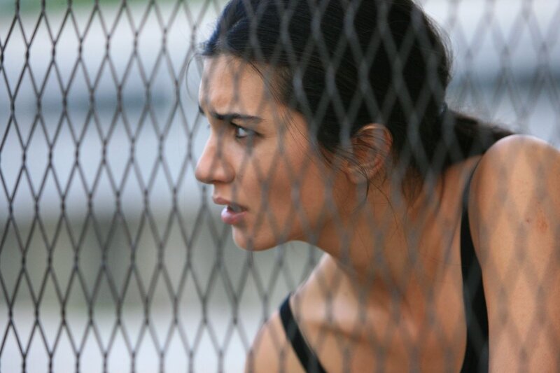woman behind chain-link fence