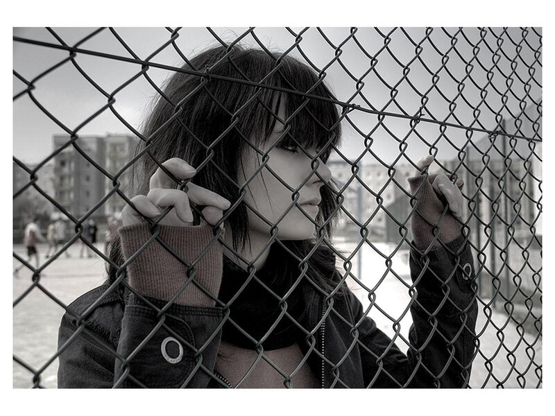woman behind chain-link fence