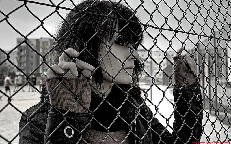 woman behind chain-link fence