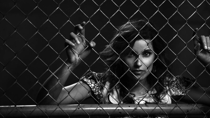 woman behind chain-link fence
