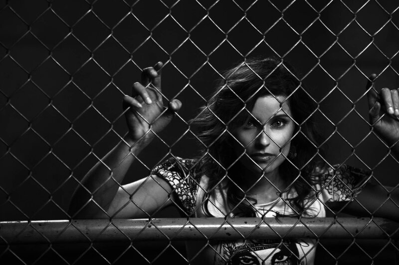 woman behind chain-link fence