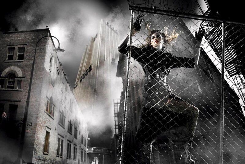 woman behind chain-link fence at night