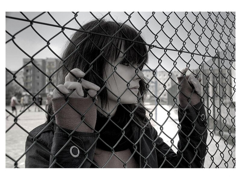woman behind chain-link fence