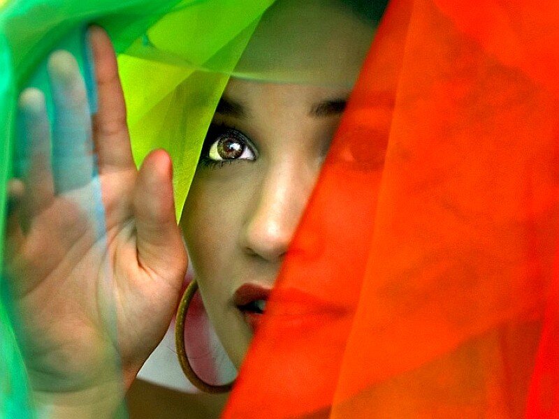 woman behind colorful fabric