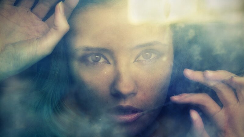 woman behind glass with smoke