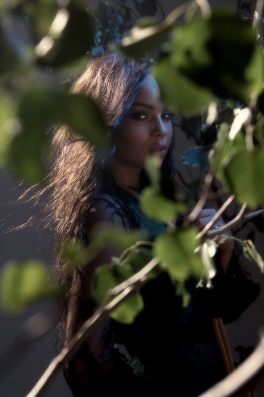 woman behind green leaves