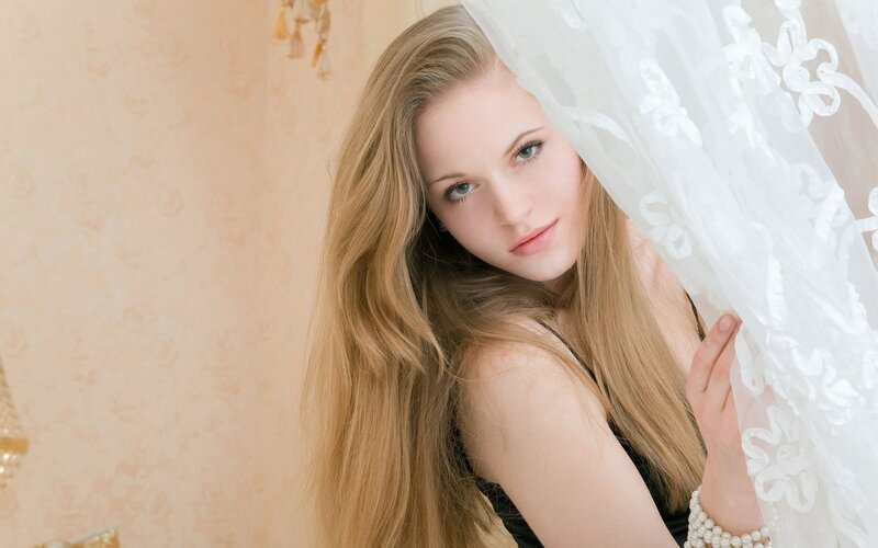woman behind lace curtain