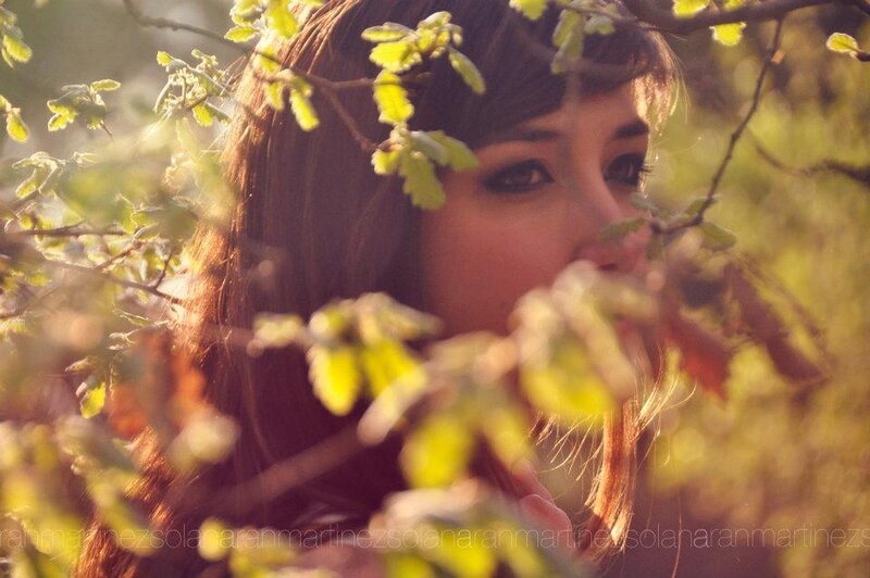 woman behind leaves in sunlight