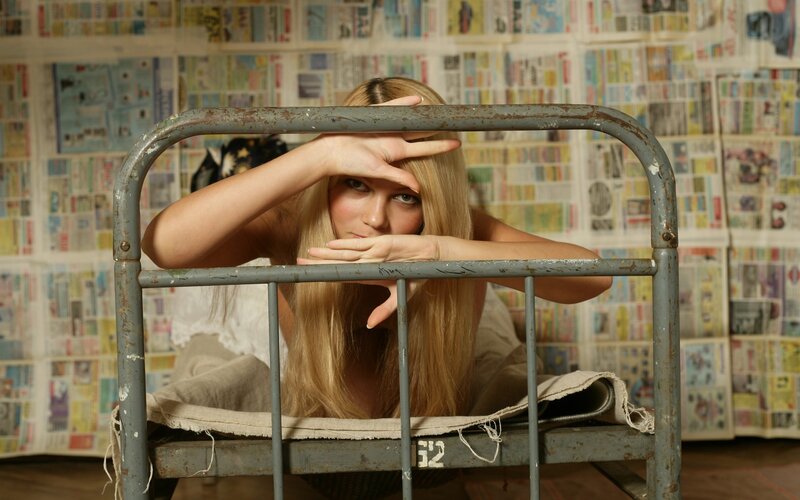 woman behind metal bed frame