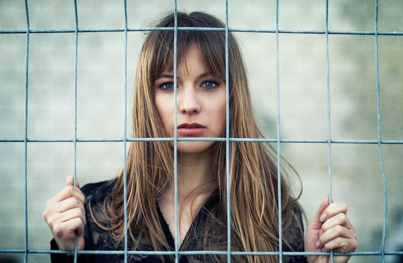 woman behind metal fence