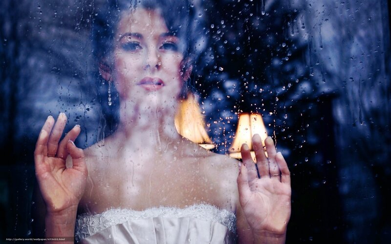 woman behind rain-streaked window