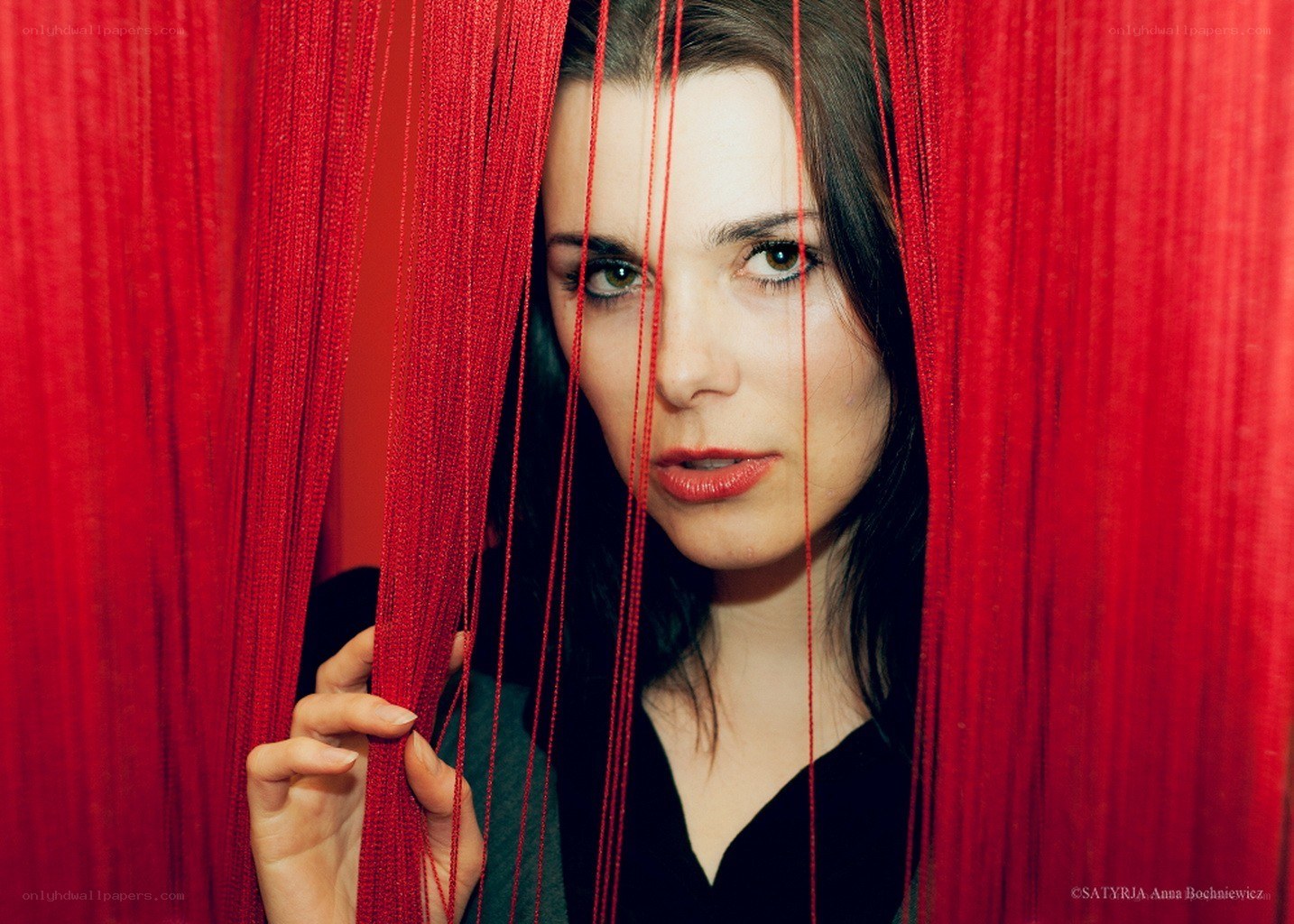 woman behind red curtain