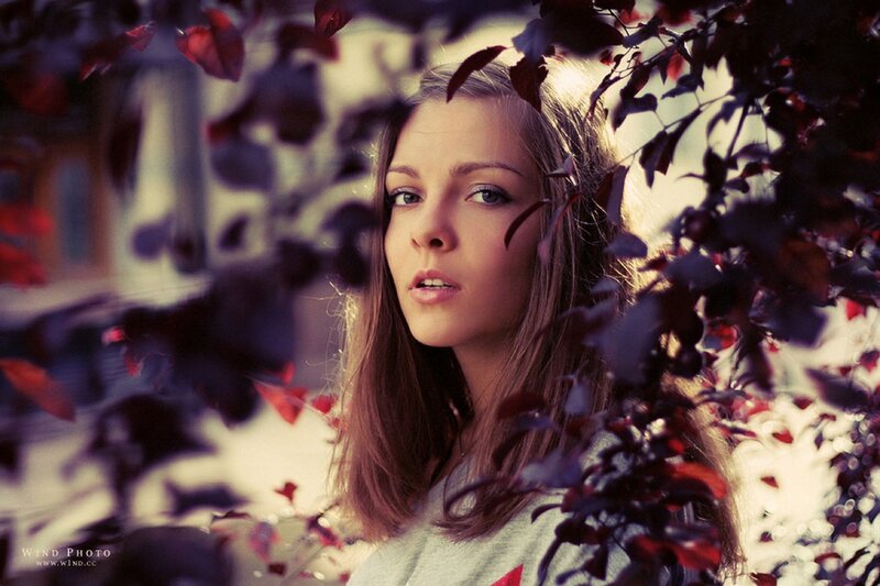 woman behind red leaves