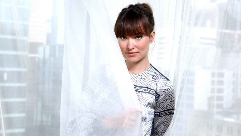 woman behind sheer curtain