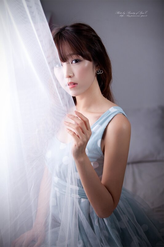 woman behind sheer curtain
