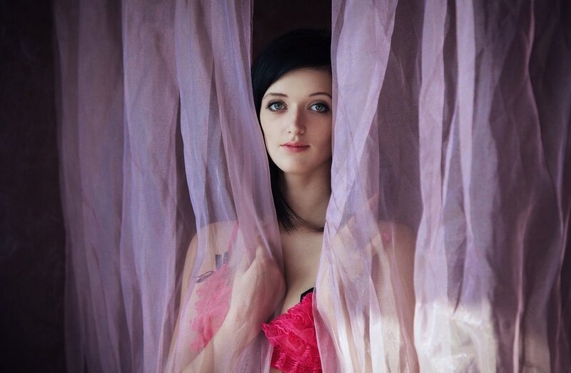 woman behind sheer curtain