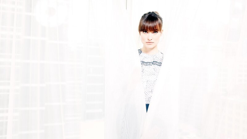 woman behind sheer curtain