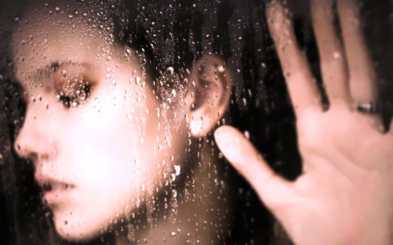 woman behind wet glass