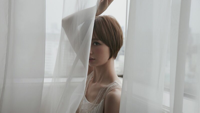 woman behind white curtain
