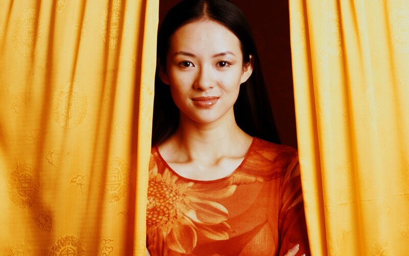 woman behind yellow curtain