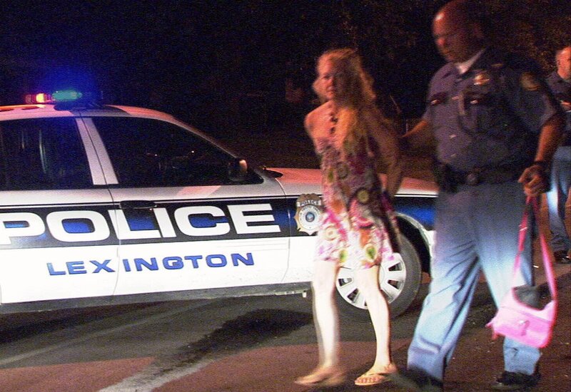 Woman Being Escorted by Officer
